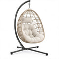 Beige PE-rotan hangstoel met zwart stalen standaard en crèmekleurige kussens, 105 x 105 x 195 cm